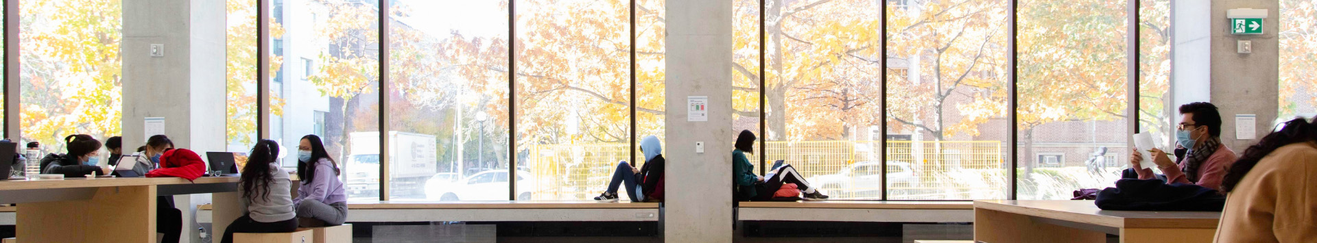 Students studying in a building with large windows